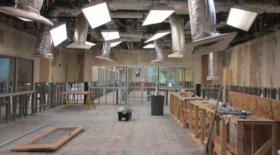 A gutted commercial space with wet floors and the lower walls removed for drying