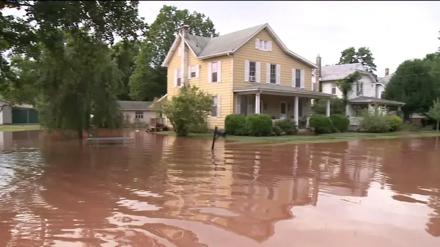 Flood cleanup in Downingtown, PA: floodwater covering the yards of two-story homes