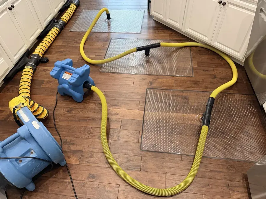 Structural drying in Downingtown, PA: drying mats and hoses on a hardwood kitchen floor